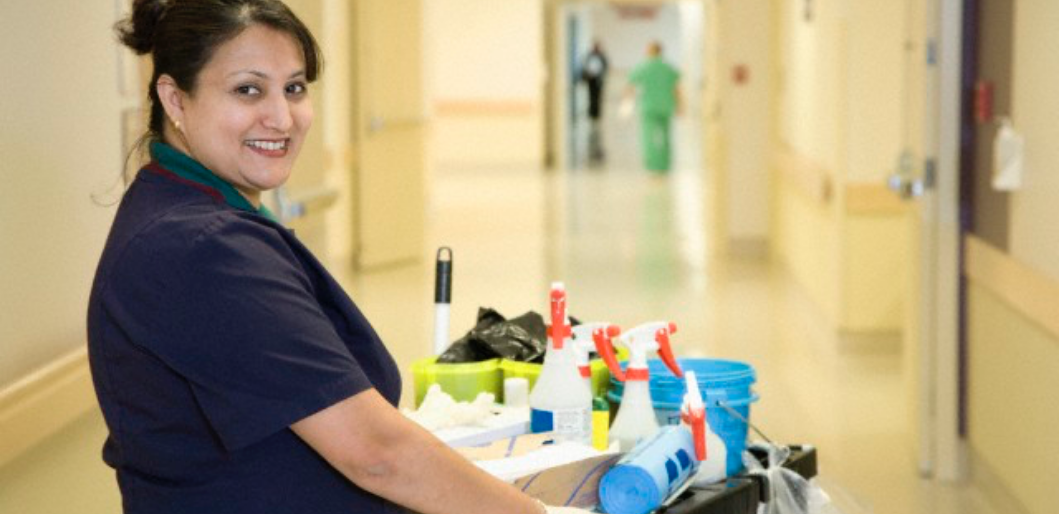 Une technicienne de surface souriante dans la couloir de l'hôpital